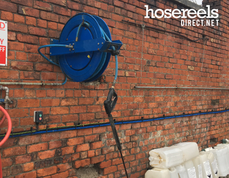 Spring rewind reel mounted at a concrete mixing plant with 400bar hose and is fitted with a lance