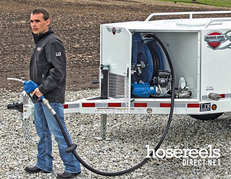 Man using a hose reel on a mobile skid for diesel dispensing 